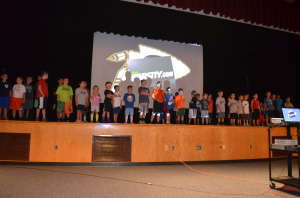 Kids singing the Sachem Fight Song on stage.