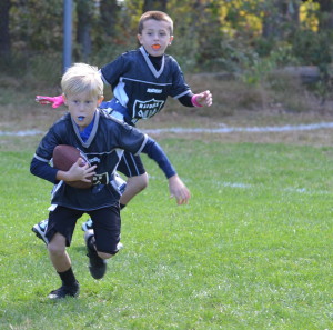 A youth player for the Raiders carries the ball at the P.A.L. Complex.